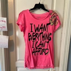 Kitson Pink short sleeve shirt says “I want everything I can’t afford”
